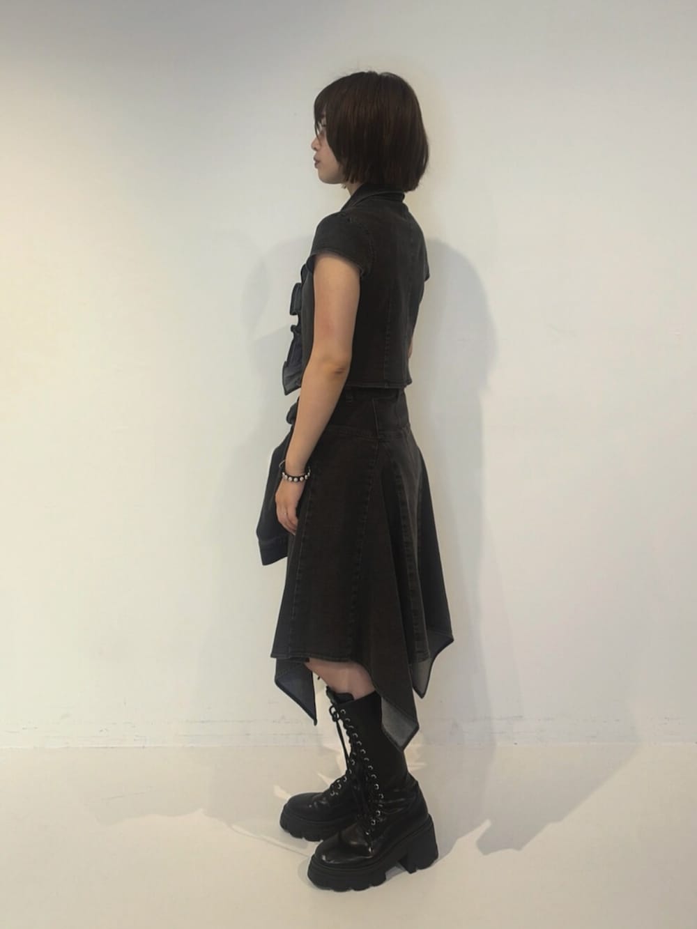 ブラック系のシャツ/ブラウス、ブラック系のスカート、ブラウン系のハンドバッグを着用したレディースの夏コーディネートの2枚目の写真