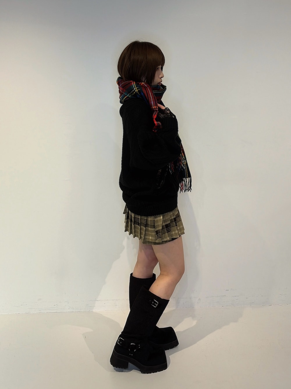 ブラック系のニット/セーター、ブラウン系のその他パンツ、ブラック系のブーツを着用したレディースの秋コーディネートの2枚目の写真