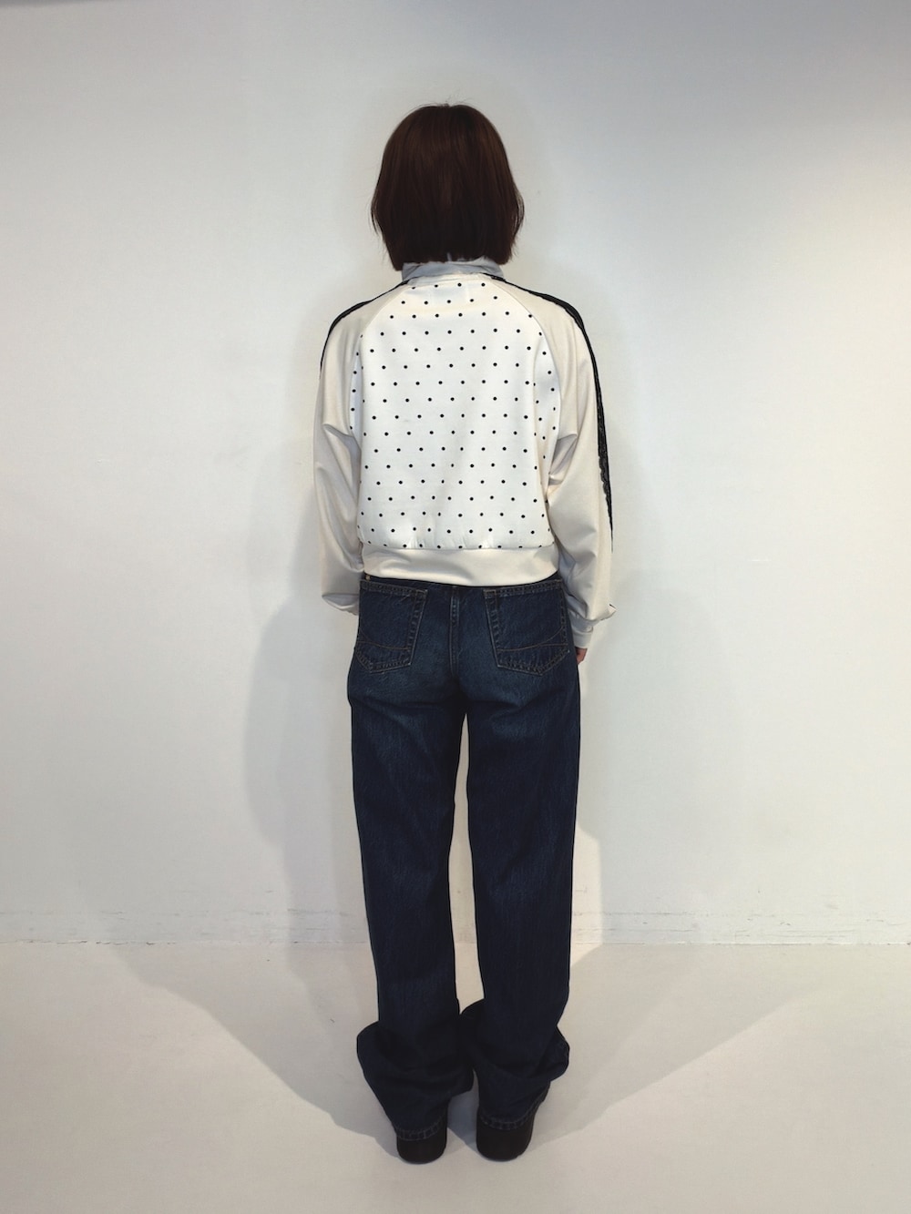 ブルー系のデニムパンツ、ホワイト系のTシャツ/カットソーを着用したレディースの秋コーディネートの4枚目の写真