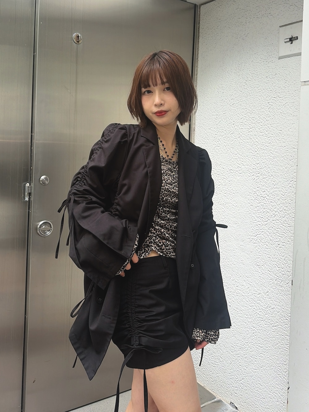 ブラウン系のTシャツ/カットソー、ブラック系のスカート、レッド系のブーツを着用したレディースの秋コーディネートの4枚目の写真
