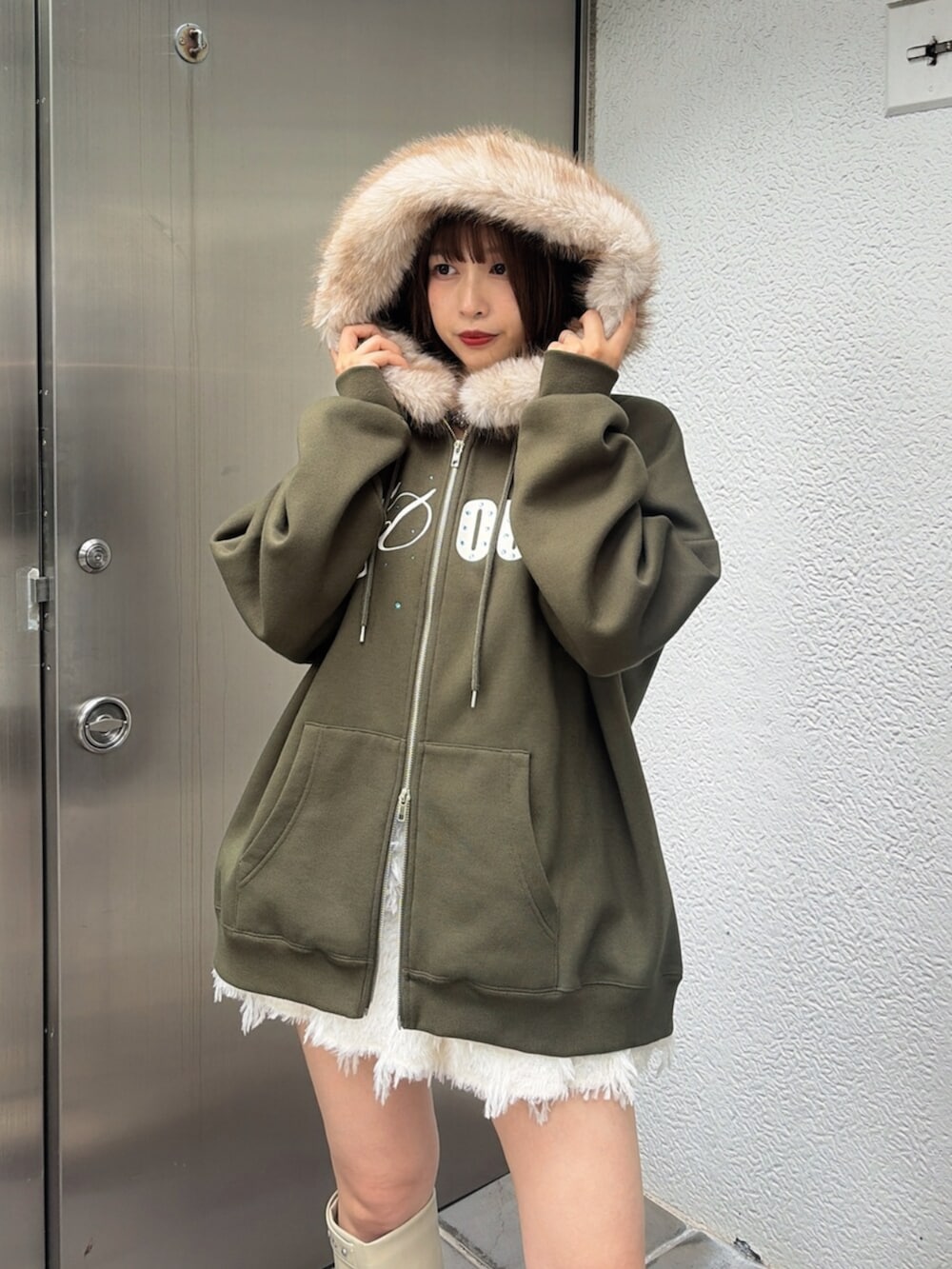 ホワイト系のスカート、ベージュ系のTシャツ/カットソー、ホワイト系のブーツを着用したレディースの秋コーディネートの5枚目の写真