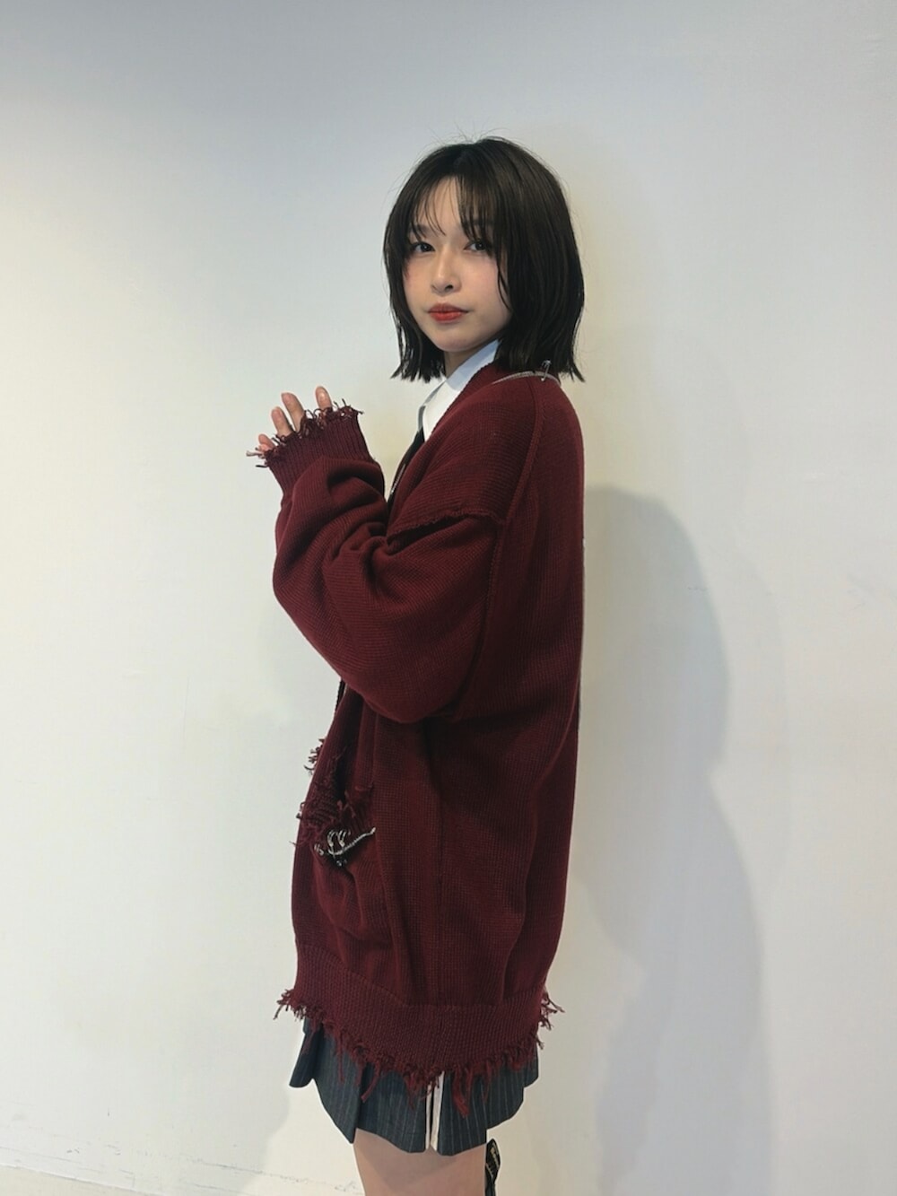 レッド系のカーディガン/ボレロ、ホワイト系のシャツ/ブラウス、グレー系のスカートを着用したレディースの夏コーディネートの5枚目の写真