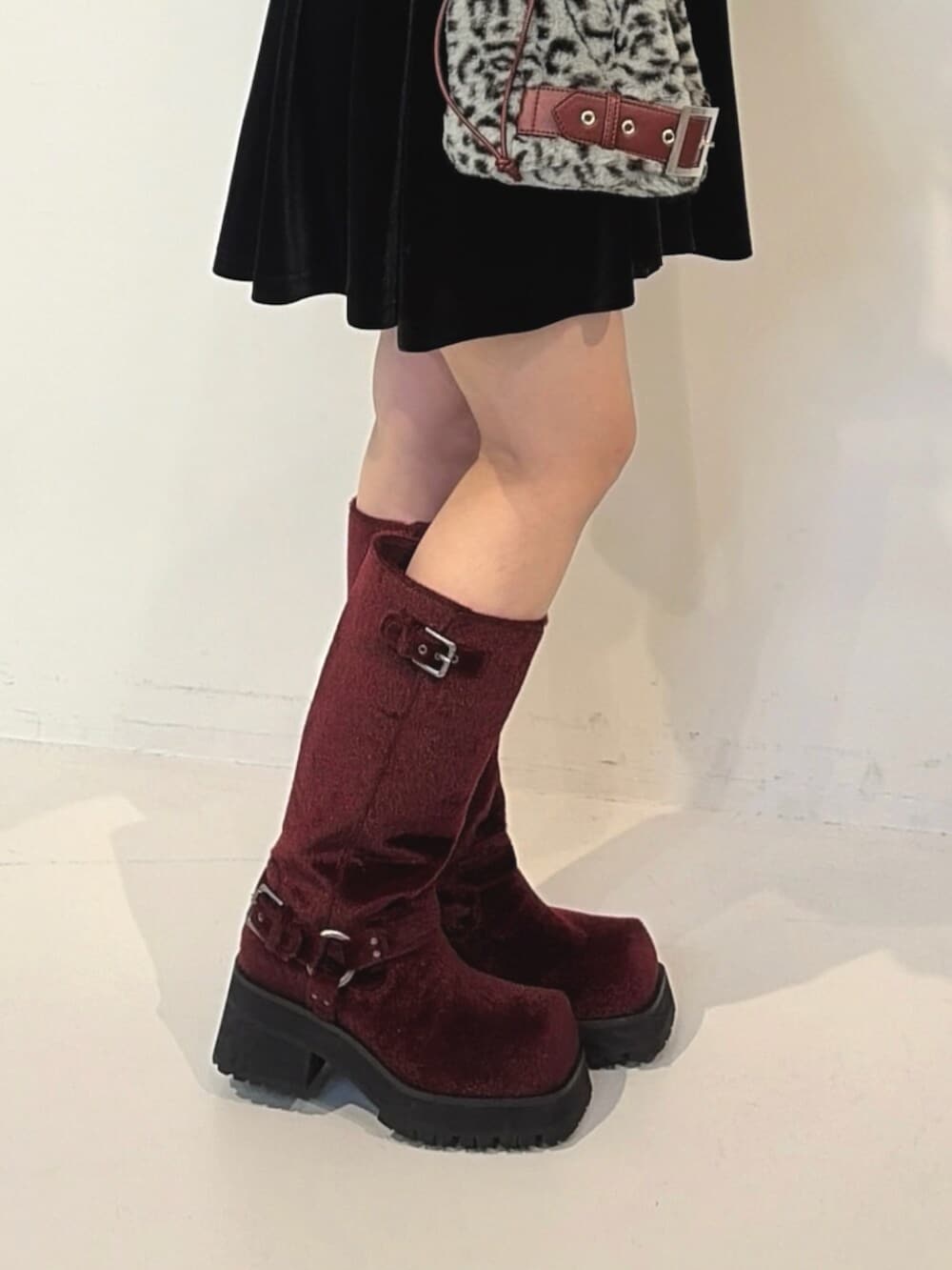 ブラック系のワンピース、グレー系のハンドバッグ、レッド系のブーツを着用したレディースの夏コーディネートの7枚目の写真