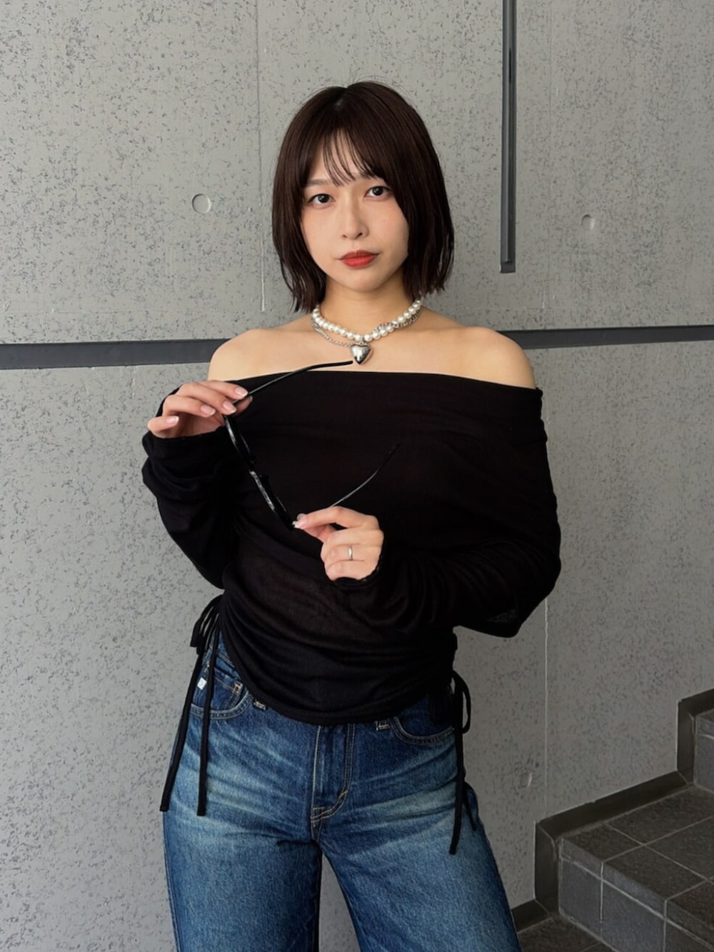 ブルー系のデニムパンツ、ブラック系のTシャツ/カットソー、ブラック系のパンプスを着用したレディースの夏コーディネートの7枚目の写真