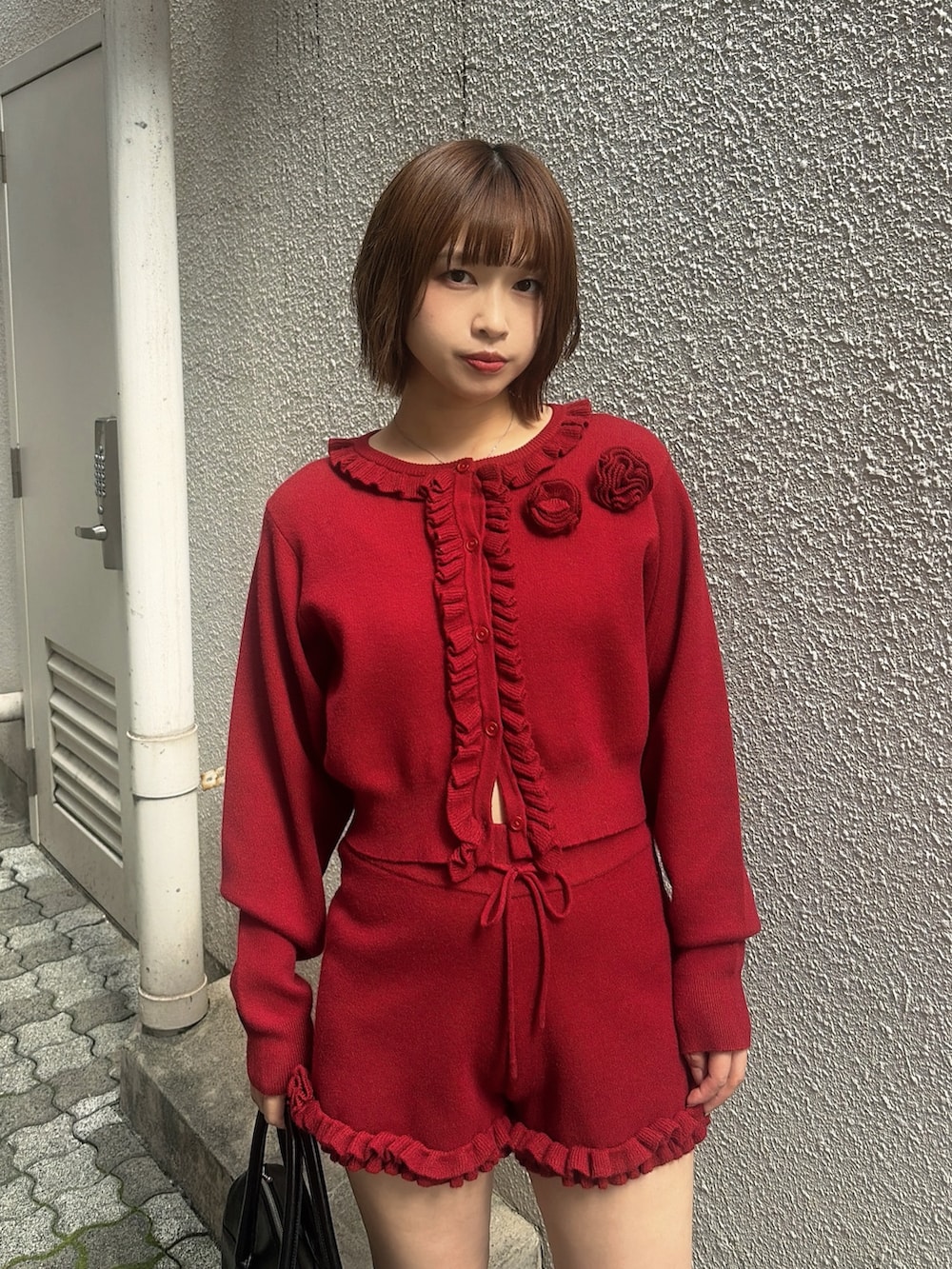 レッド系のカーディガン/ボレロ、レッド系のその他パンツ、ブラック系のハンドバッグを着用したレディースの秋コーディネートの5枚目の写真