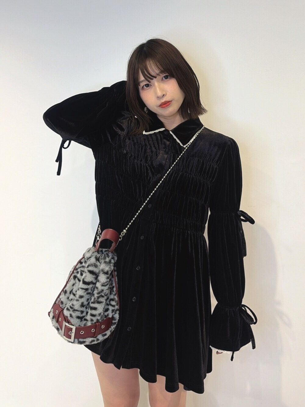 ブラック系のワンピース、グレー系のハンドバッグ、レッド系のブーツを着用したレディースの夏コーディネートの5枚目の写真