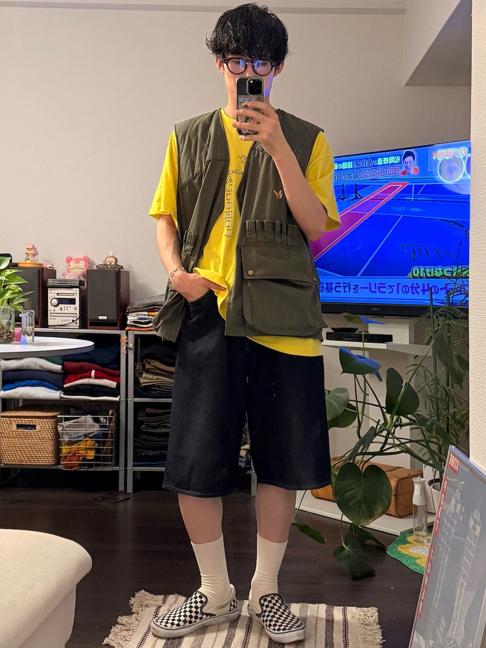 ブルー系のデニムパンツ、ホワイト系のスリッポン、ブラウン系のメガネを着用したメンズの夏コーディネートの2枚目の写真