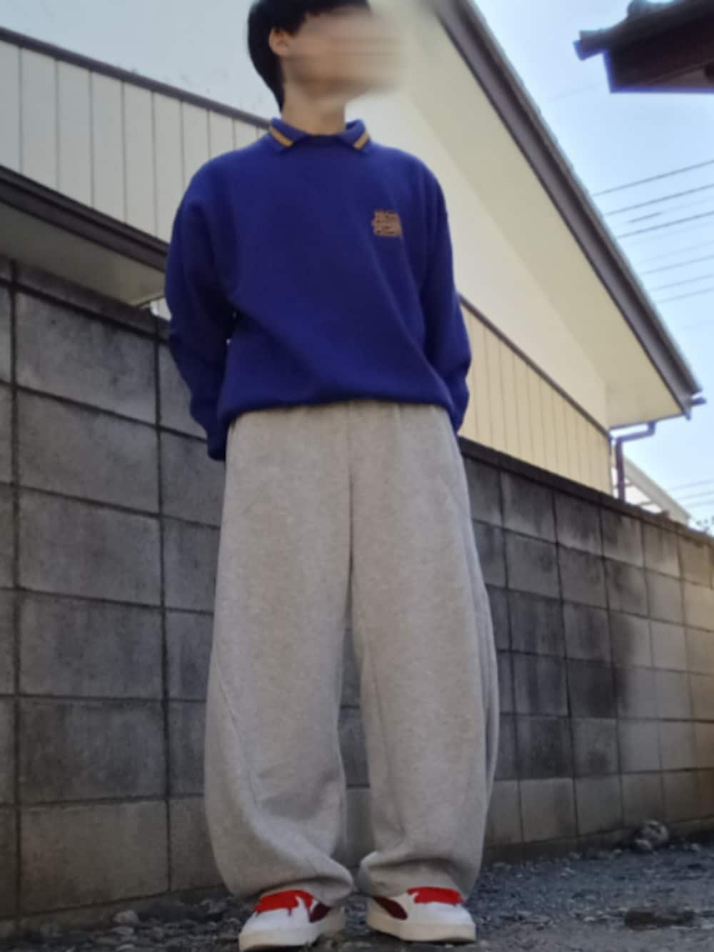 ブルー系のスウェット、グレー系のスウェットパンツ、ホワイト系のスニーカーを着用したメンズの冬コーディネートの2枚目の写真