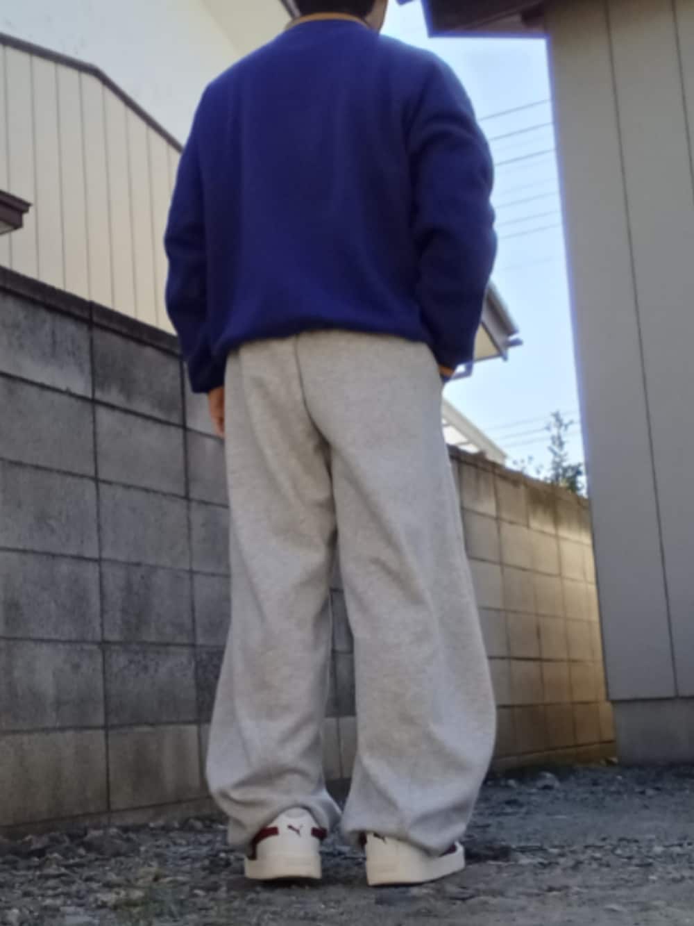 ブルー系のスウェット、グレー系のスウェットパンツ、ホワイト系のスニーカーを着用したメンズの冬コーディネートの3枚目の写真