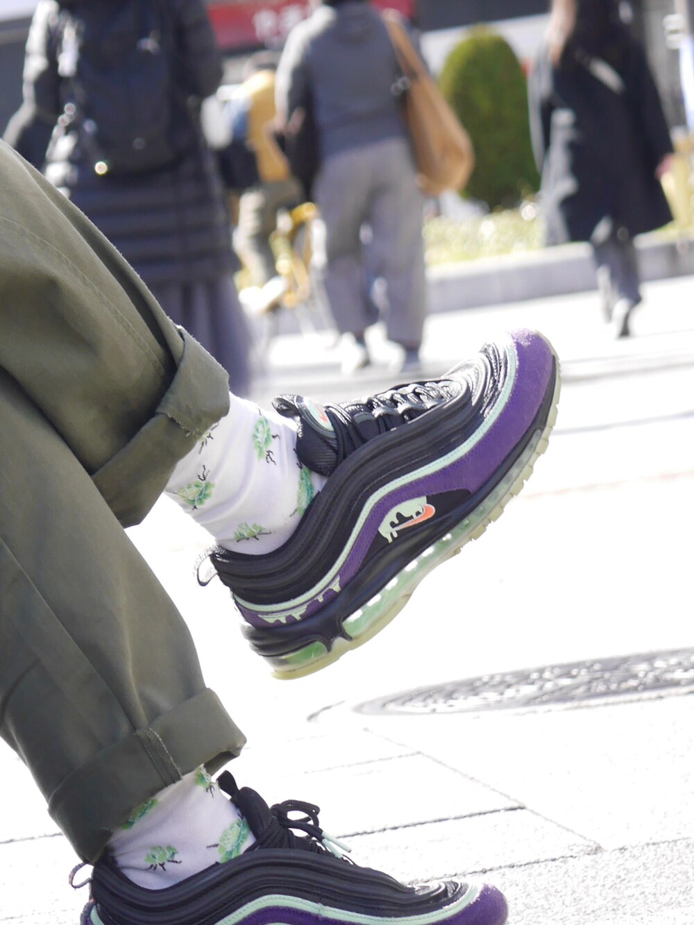 グリーン系のカーゴパンツ、パープル系のスニーカー、ブラック系のスウェットを着用したメンズの春コーディネートの3枚目の写真