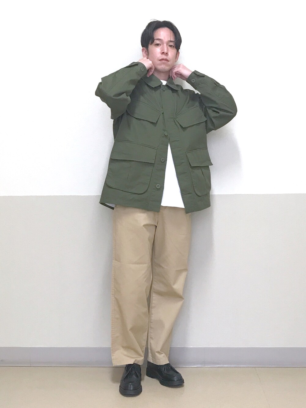 グリーン系のミリタリージャケット、ベージュ系のチノパンツ、ホワイト系のTシャツ/カットソーを着用したメンズの春コーディネートの2枚目の写真
