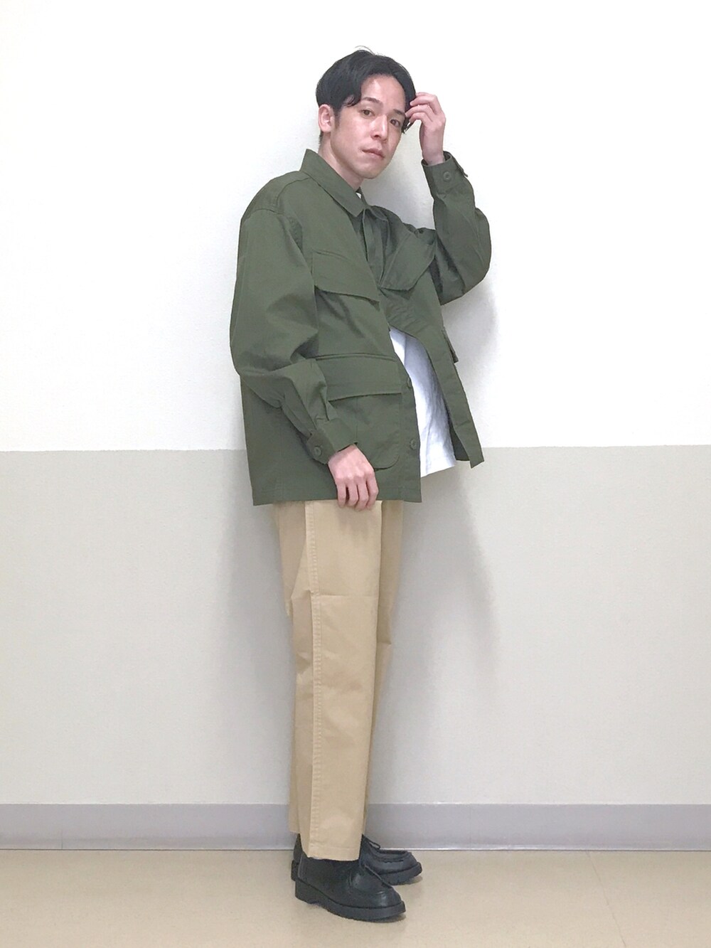 グリーン系のミリタリージャケット、ベージュ系のチノパンツ、ホワイト系のTシャツ/カットソーを着用したメンズの春コーディネートの3枚目の写真