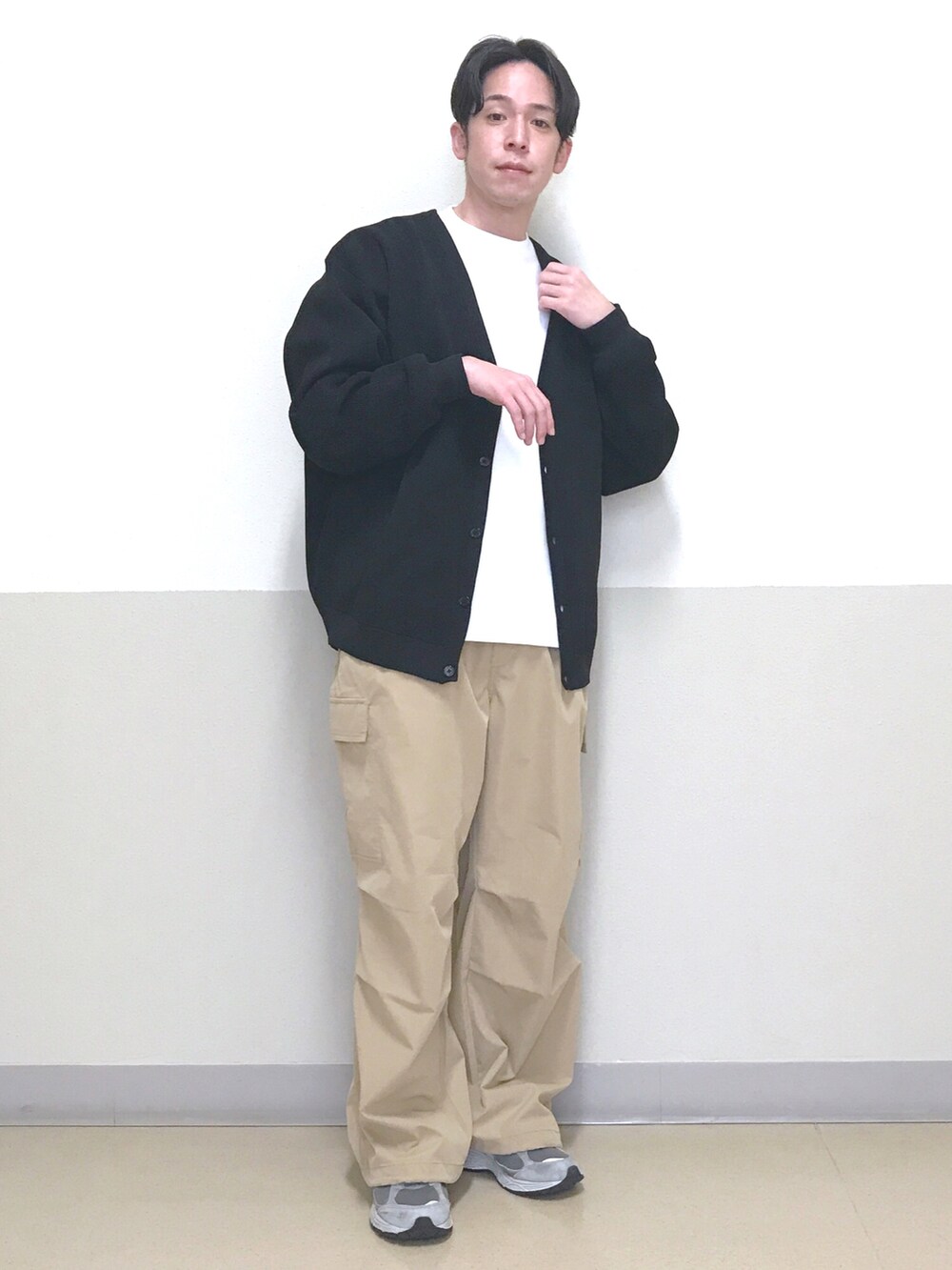 ブラック系のカーディガン/ボレロ、ホワイト系のTシャツ/カットソー、ベージュ系のカーゴパンツを着用したメンズの春コーディネートの2枚目の写真