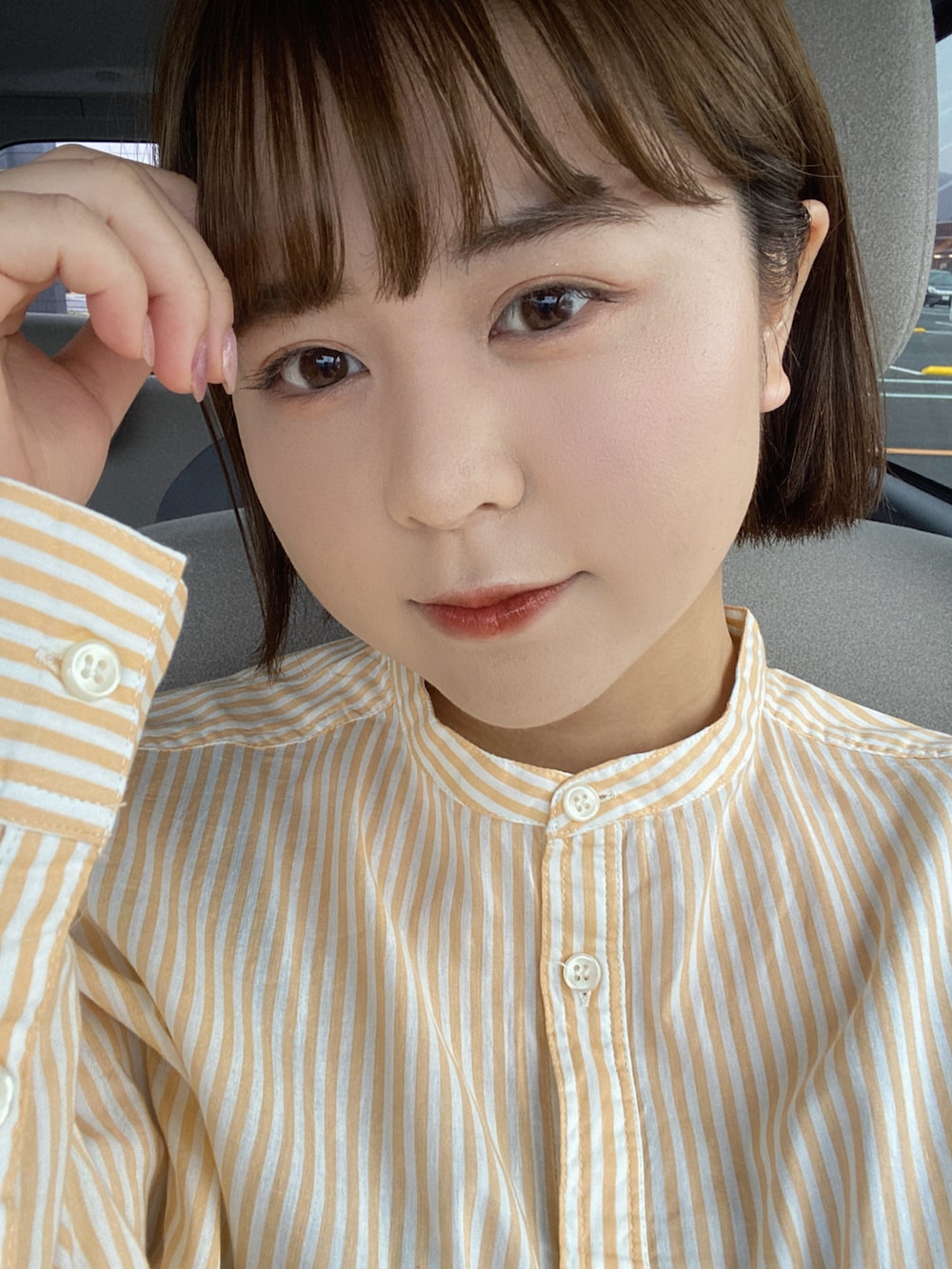 ブラウン系のその他パンツ、グレー系のジャケット/アウター、オレンジ系のシャツ/ブラウスを着用したレディースの春コーディネートの2枚目の写真