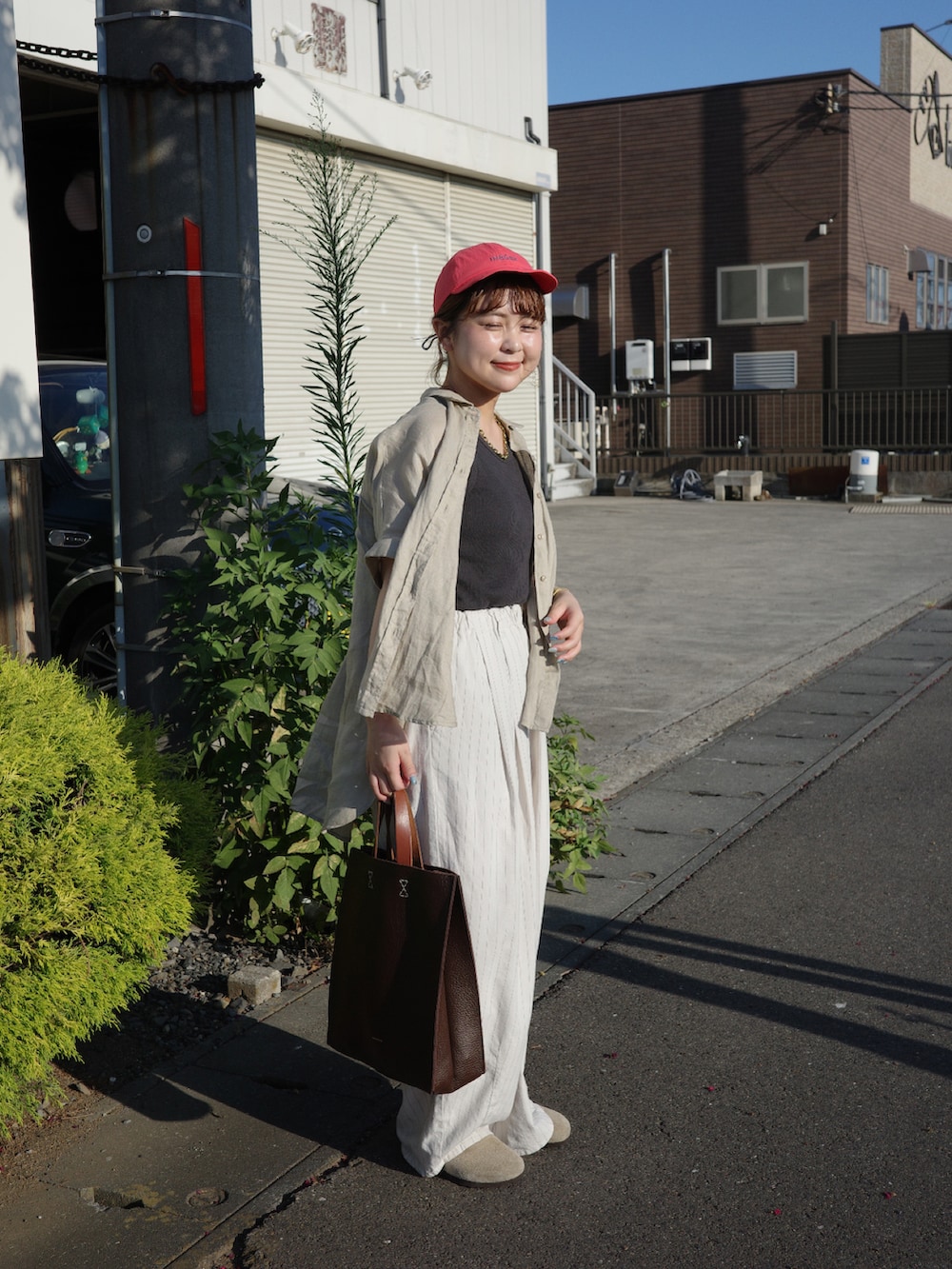 ブラウン系のハンドバッグ、その他のその他パンツ、ベージュ系のシャツ/ブラウスを着用したレディースの夏コーディネートの3枚目の写真