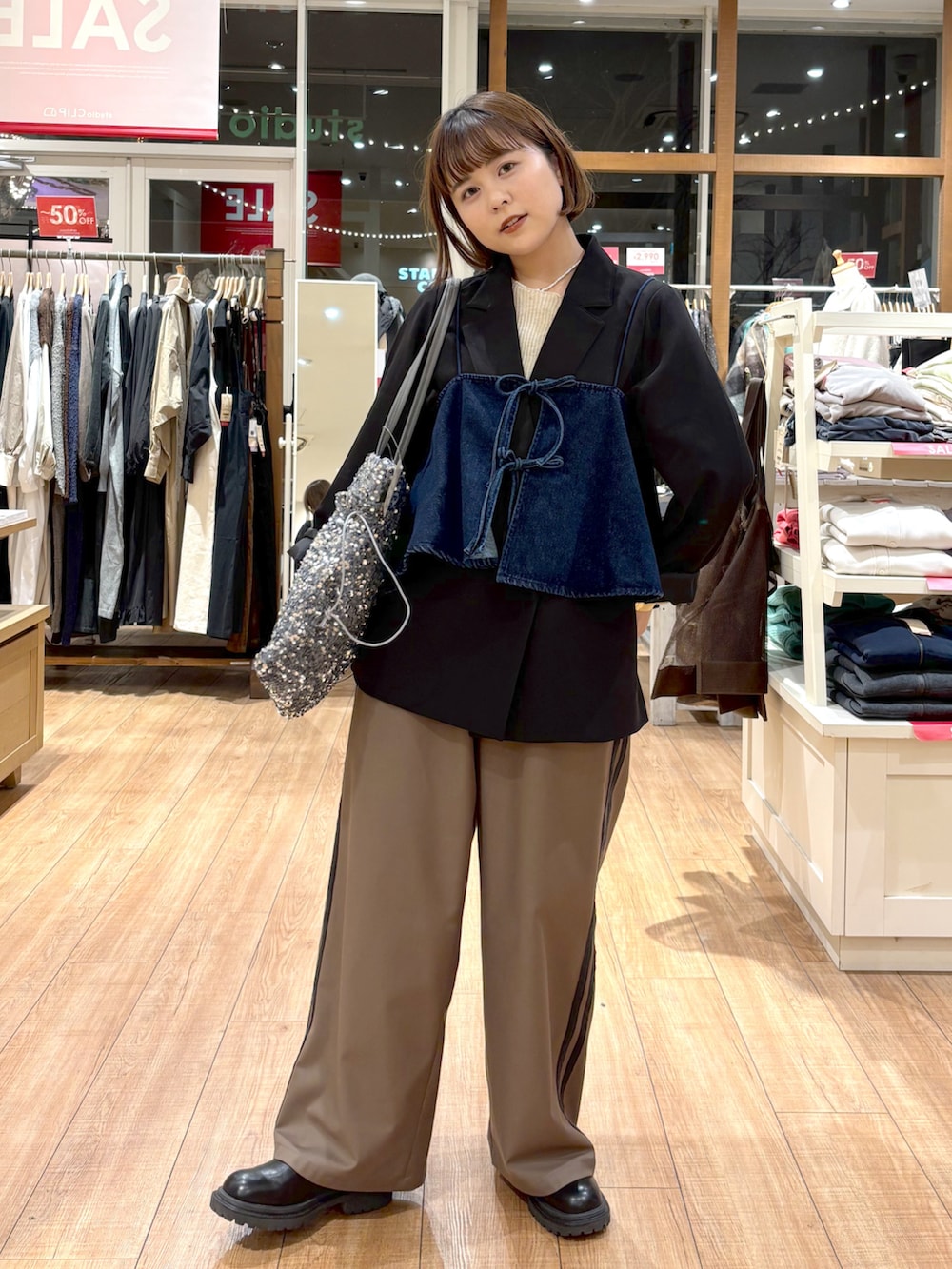 ブラック系のテーラードジャケット、ブルー系のその他トップス、ブラウン系のその他パンツを着用したレディースの冬コーディネートの3枚目の写真