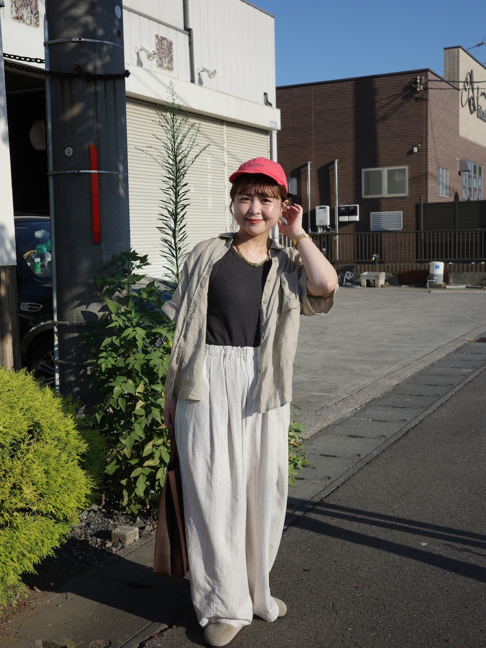 ブラウン系のハンドバッグ、その他のその他パンツ、ベージュ系のシャツ/ブラウスを着用したレディースの夏コーディネートの2枚目の写真