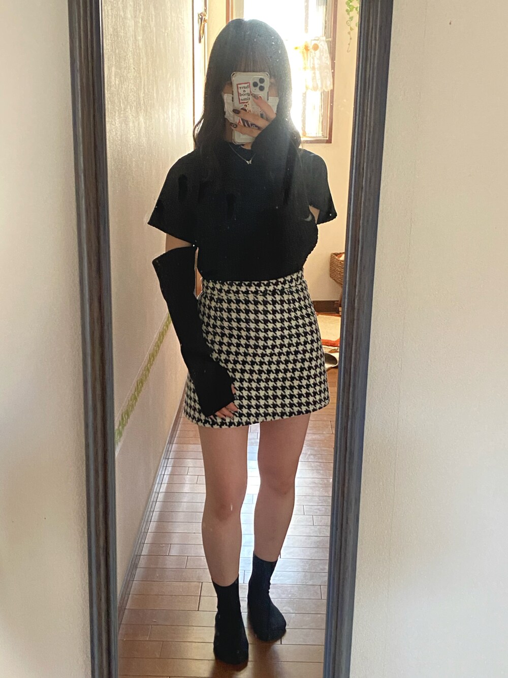 ブラック系のブーツ、ホワイト系のノーカラージャケット、ベージュ系のベストを着用したレディースの春コーディネートの2枚目の写真