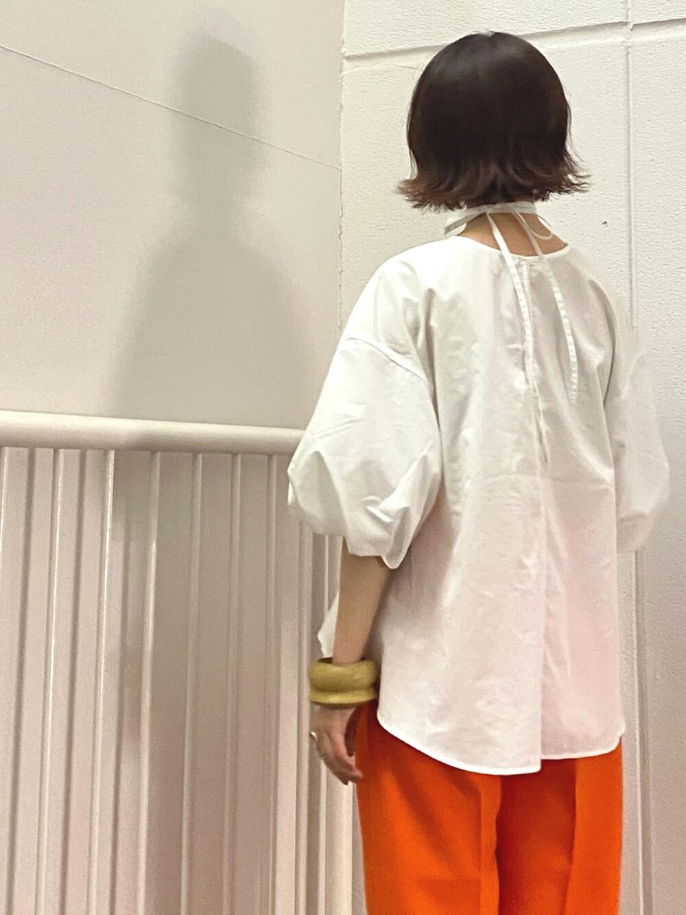 オレンジ系のその他パンツ、ホワイト系のシャツ/ブラウス、グリーン系のサンダルを着用したレディースの春コーディネートの2枚目の写真