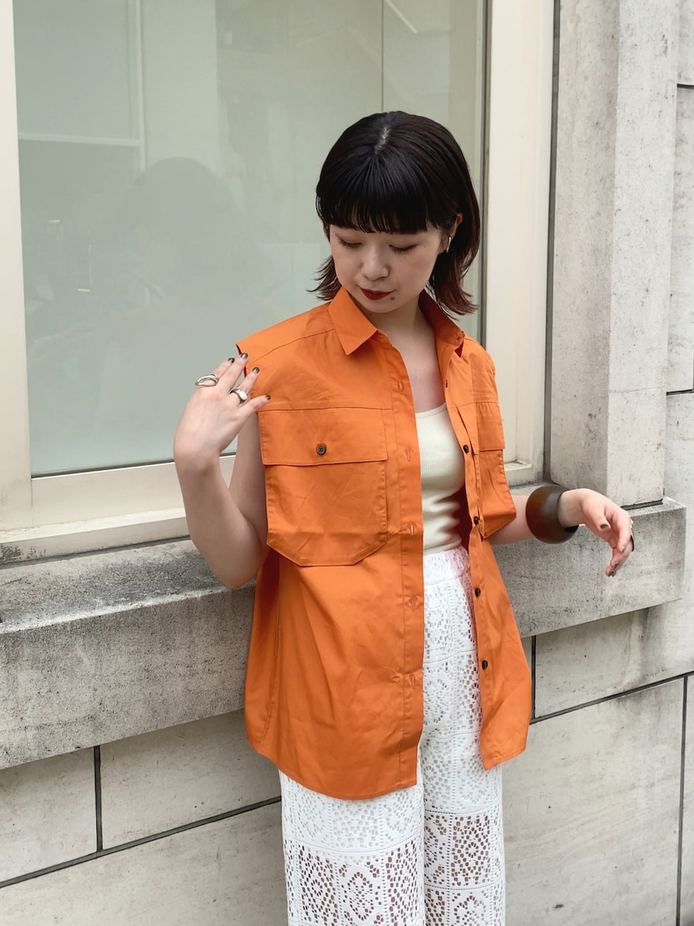 オレンジ系のシャツ/ブラウス、ホワイト系のその他パンツを着用したレディースの夏コーディネートの2枚目の写真