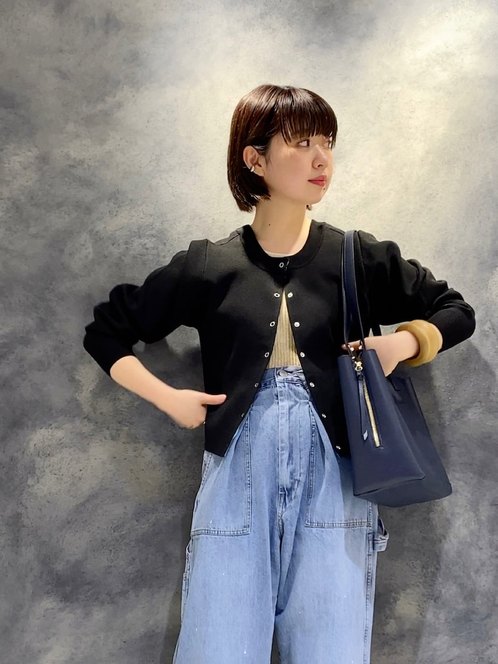 ブルー系のデニムパンツ、ブルー系のトートバッグ、ブラック系のサンダルを着用したレディースの冬コーディネートの2枚目の写真