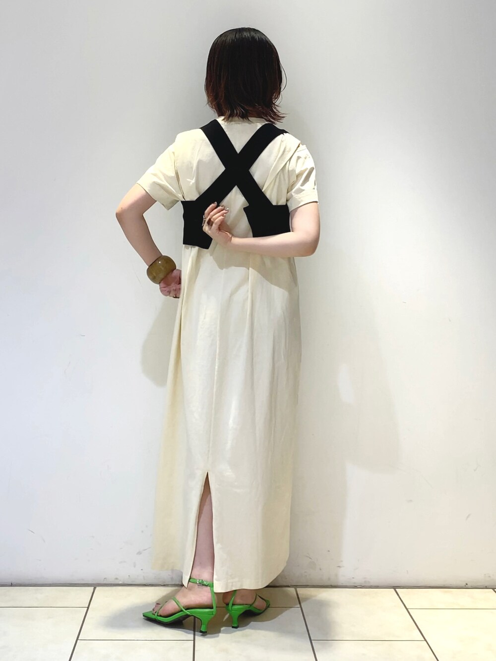 ホワイト系のワンピース、グリーン系のハンドバッグ、オレンジ系のサンダルを着用したレディースの夏コーディネートの3枚目の写真