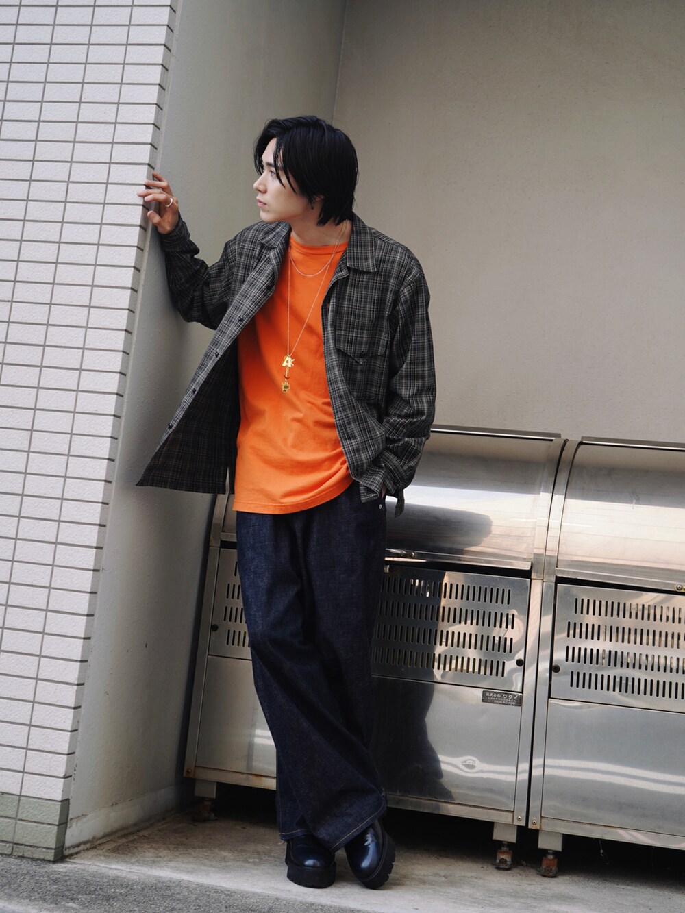 オレンジ系のTシャツ/カットソー、ブラウン系のシャツ/ブラウス、ブルー系のデニムパンツを着用したメンズの春コーディネートの2枚目の写真