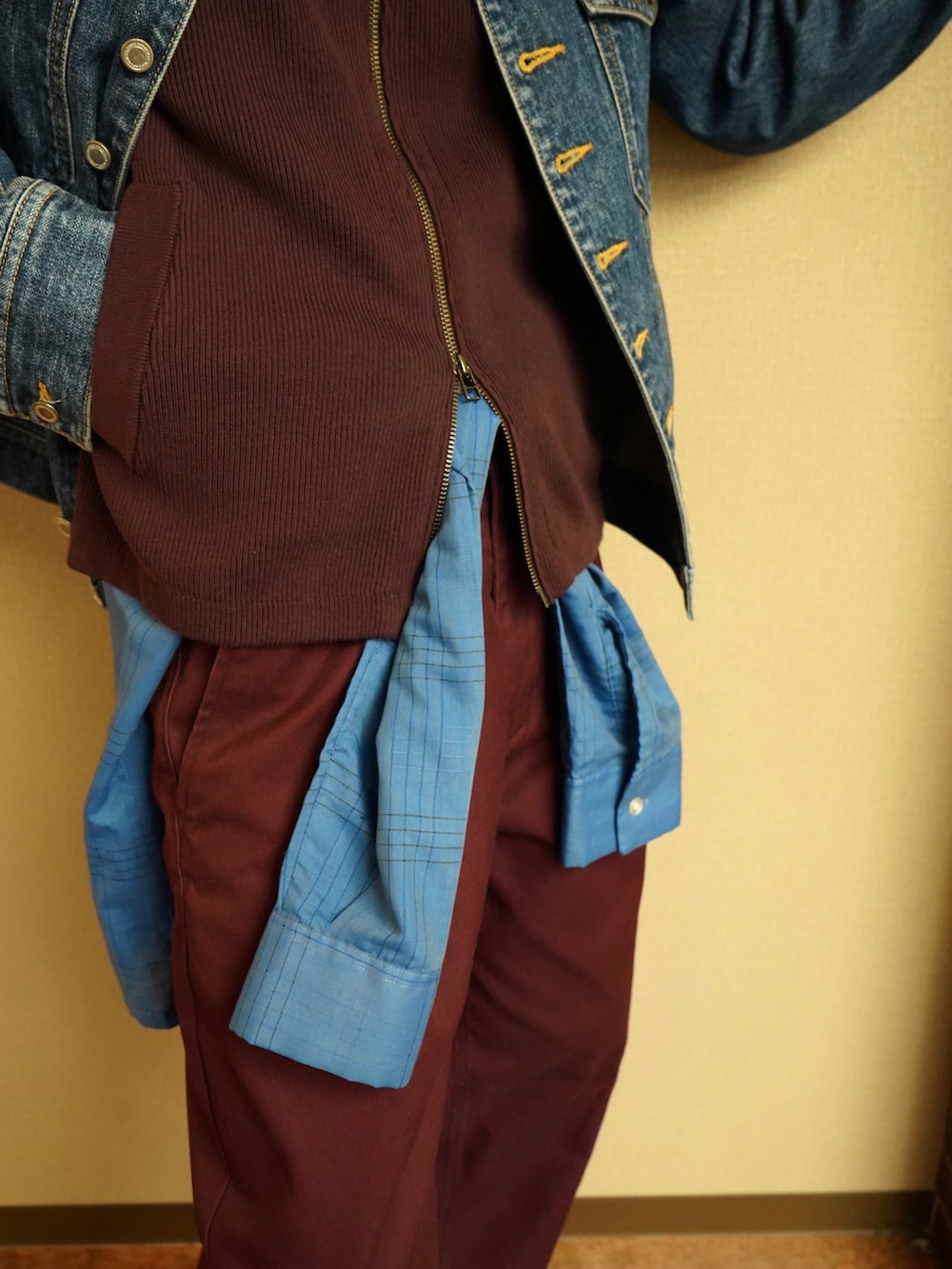 レッド系のニット/セーター、ブルー系のデニムジャケット、ブルー系のシャツ/ブラウスを着用したメンズの秋コーディネートの3枚目の写真