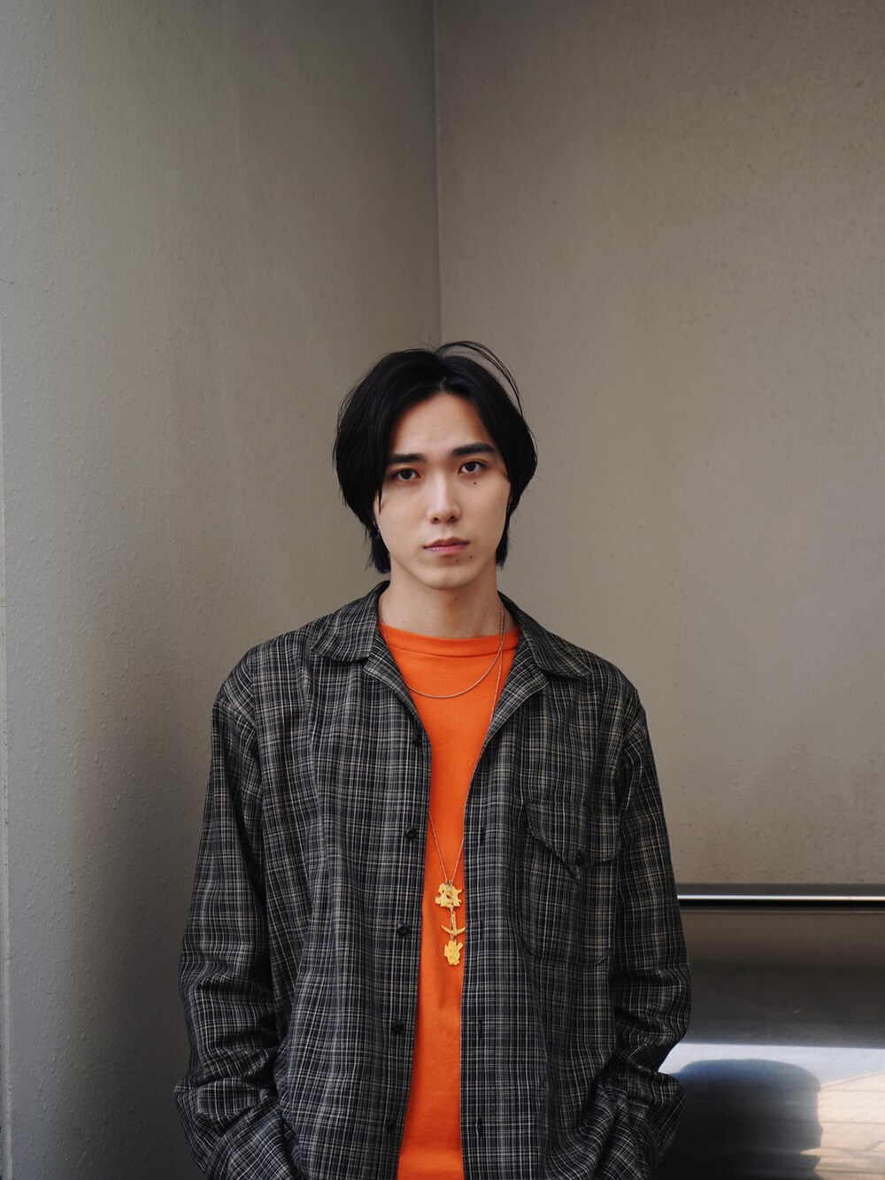 オレンジ系のTシャツ/カットソー、ブラウン系のシャツ/ブラウス、ブルー系のデニムパンツを着用したメンズの春コーディネートの3枚目の写真