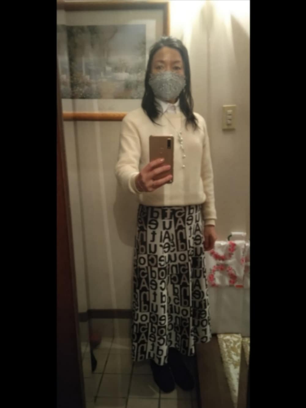 ブラック系のブーツ、グレー系のスカート、ブラウン系のショルダーバッグを着用したレディースの冬コーディネートの2枚目の写真