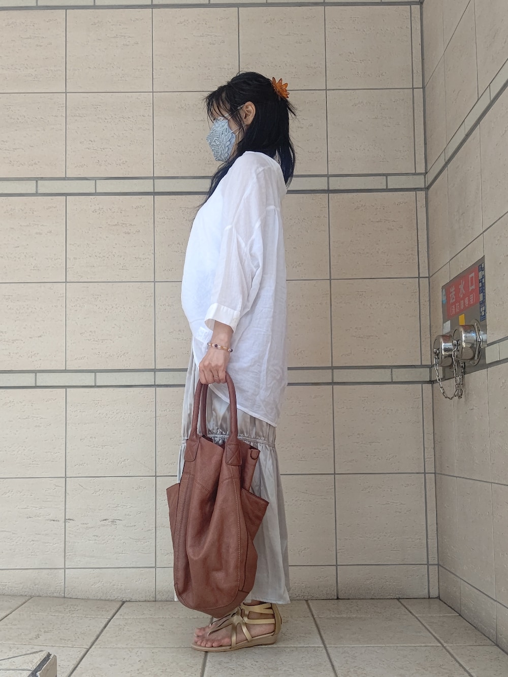 ゴールド系のその他シューズ、ブラウン系のトートバッグ、ゴールド系のスカートを着用したレディースの春コーディネートの2枚目の写真