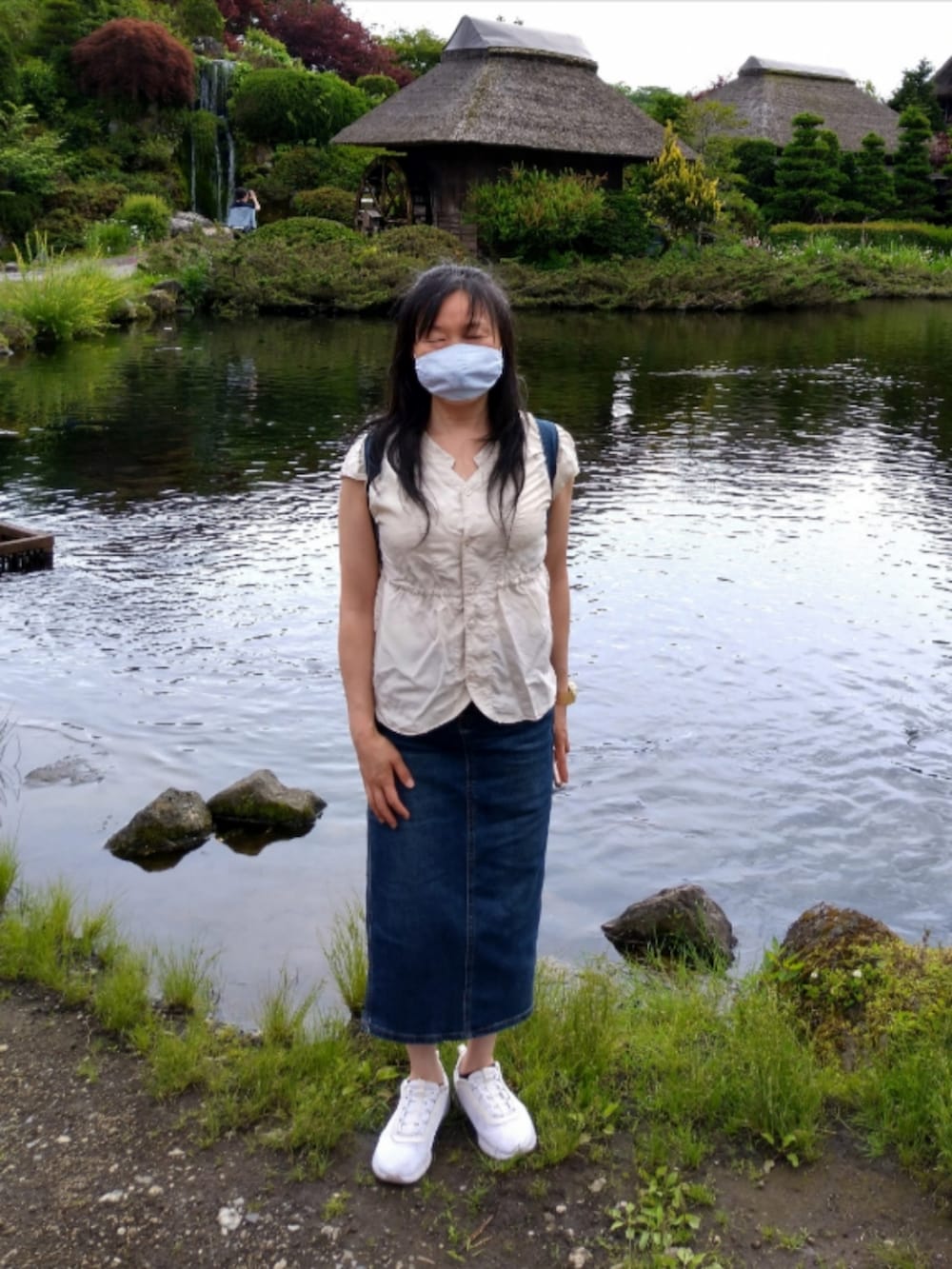 ホワイト系のスニーカー、ブルー系のデニムスカート、ブルー系のバックパック/リュックを着用したレディースの夏コーディネートの2枚目の写真