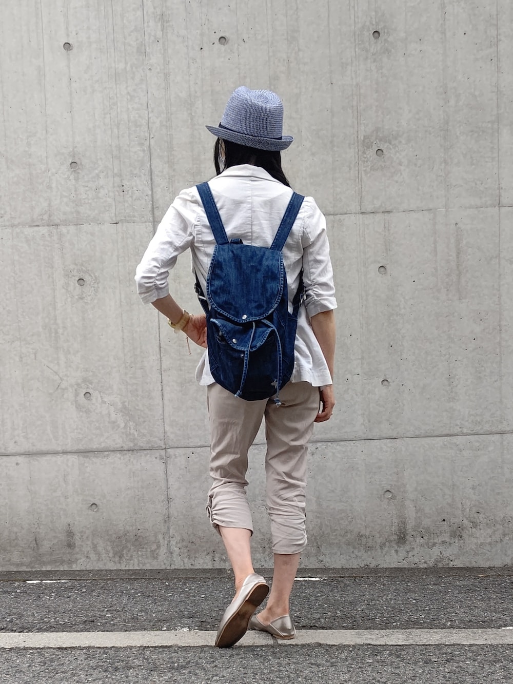 ブルー系のバックパック/リュック、ゴールド系のスリッポン、ベージュ系のテーラードジャケットを着用したレディースの春コーディネートの2枚目の写真