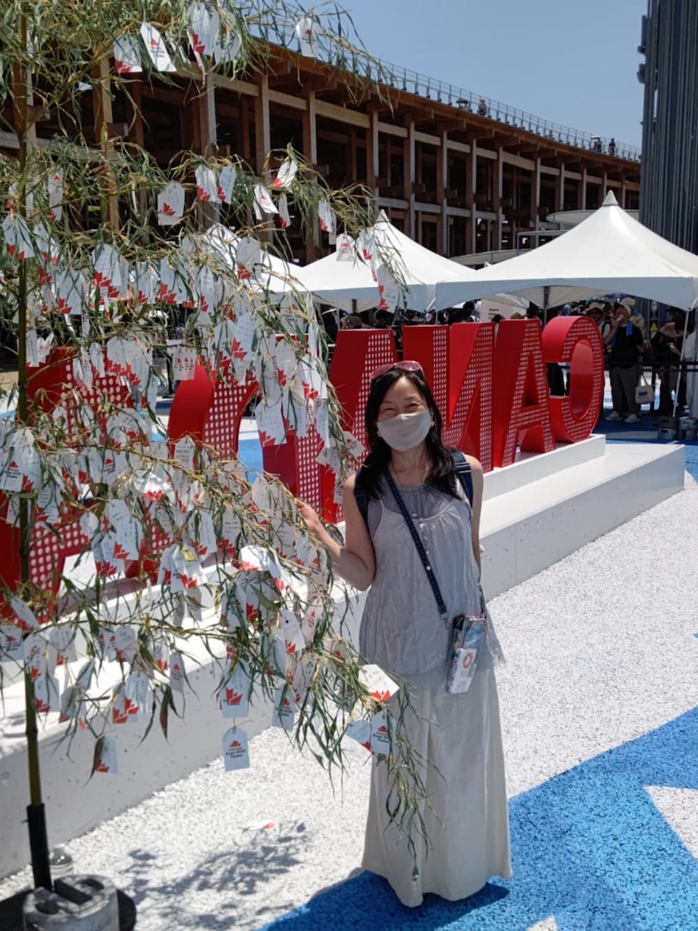 ブラウン系のサンダル、グレー系のパンツ、シルバー系のキャミソールを着用したレディースの夏コーディネートの2枚目の写真