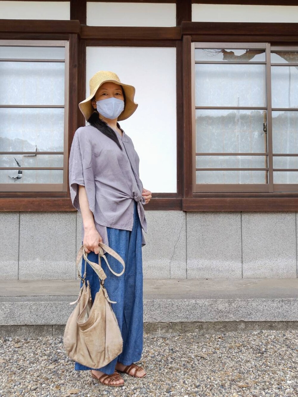 グレー系のその他トップス、ブルー系のパンツ、ベージュ系のショルダーバッグを着用したレディースの春コーディネートの2枚目の写真