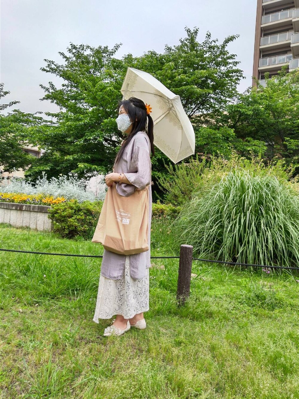 シルバー系のその他アウター、ベージュ系のシューズ、ベージュ系のエコバッグ/サブバッグを着用したレディースの春コーディネートの2枚目の写真