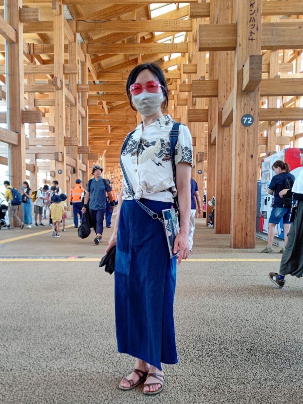 ブラウン系のサンダル、ブルー系のデニムスカート、ベージュ系のシャツ/ブラウスを着用したレディースの夏コーディネートの2枚目の写真