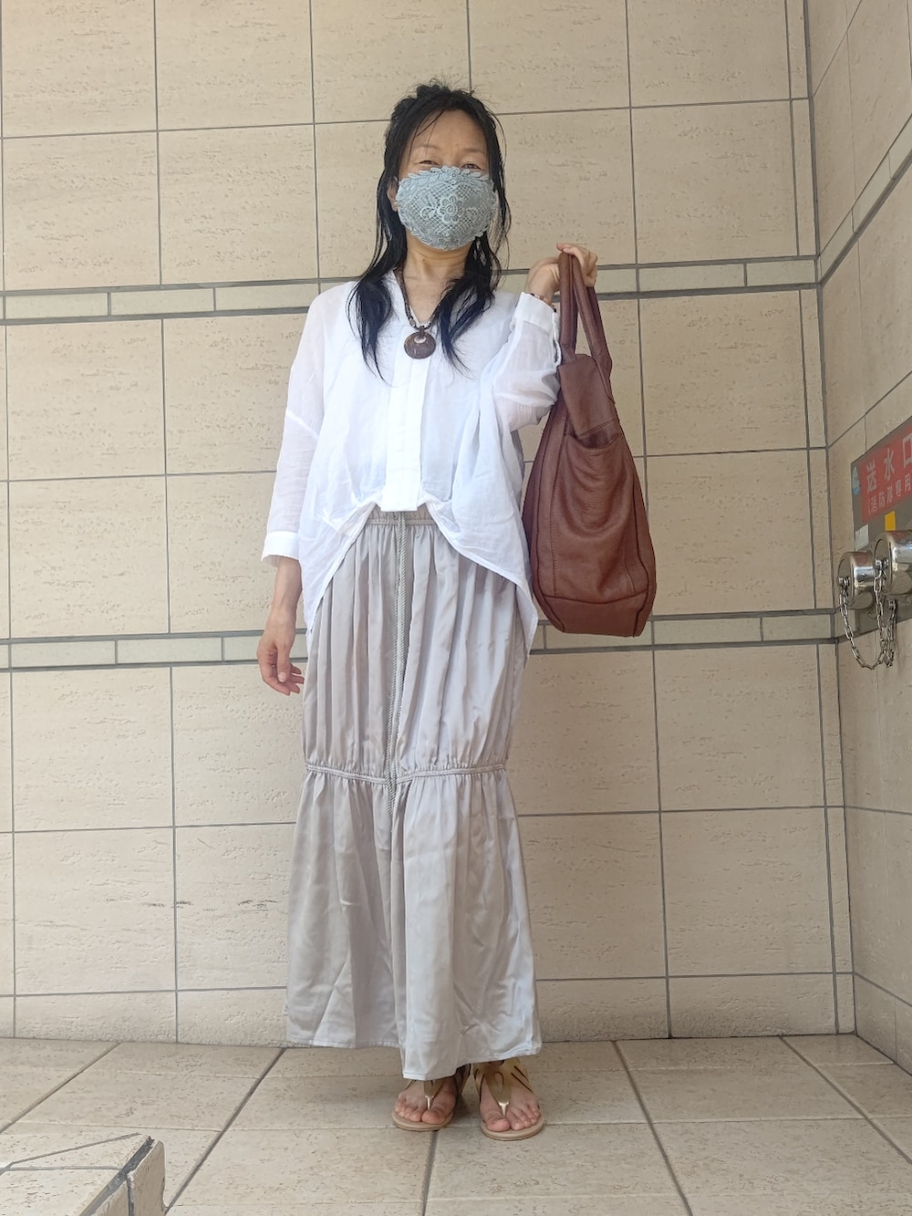 ゴールド系のその他シューズ、ブラウン系のトートバッグ、ゴールド系のスカートを着用したレディースの春コーディネートの3枚目の写真