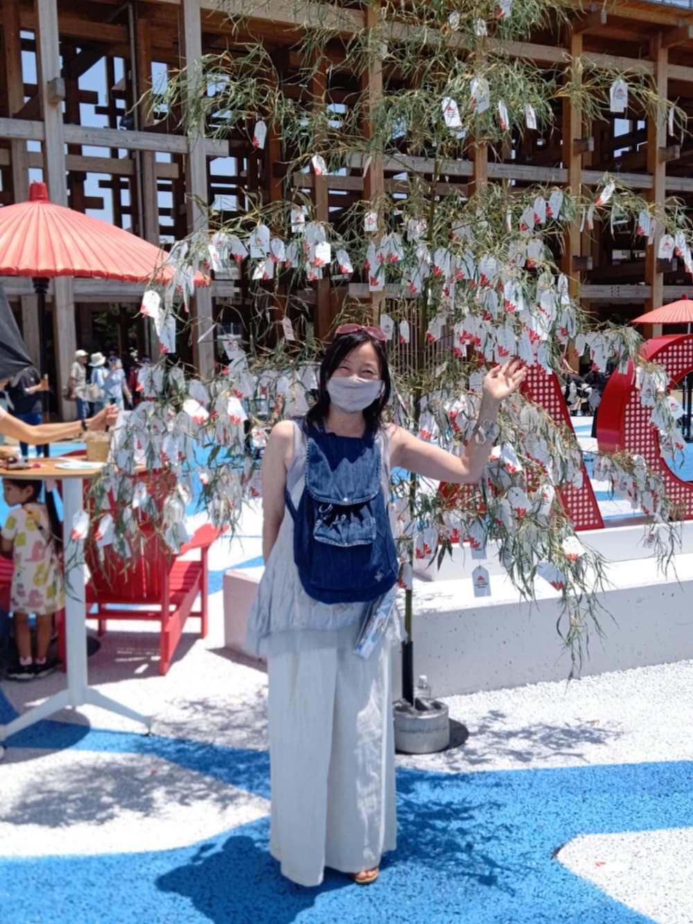 ブラウン系のサンダル、グレー系のパンツ、シルバー系のキャミソールを着用したレディースの夏コーディネートの3枚目の写真