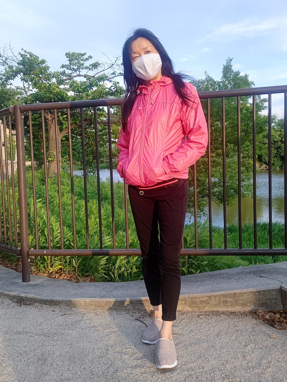 ピンク系のナイロンジャケット、ブラック系のパンツ、ベージュ系のその他を着用したレディースの春コーディネートの2枚目の写真