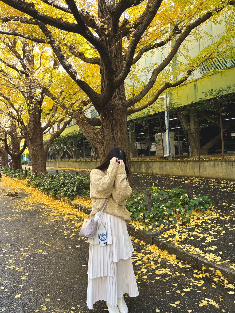 イエロー系のニット/セーター、ホワイト系のスカートを着用したレディースの冬コーディネートの2枚目の写真