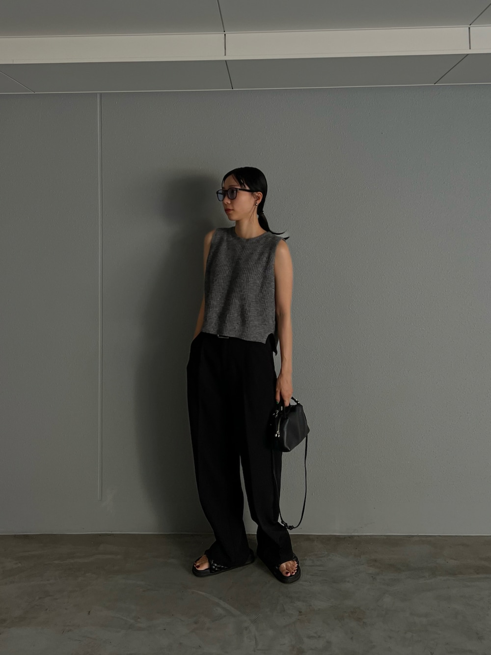グレー系のベスト、ブラック系のその他パンツ、ブラック系のショルダーバッグを着用したレディースの秋コーディネートの2枚目の写真