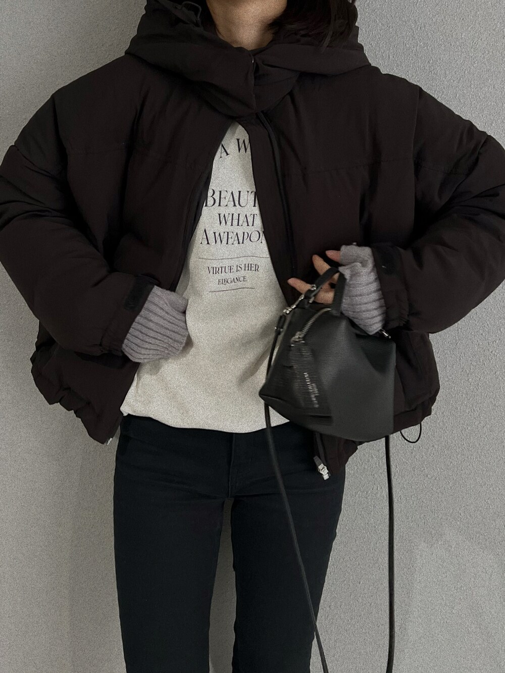 グレー系のスニーカー、ブラック系のショルダーバッグ、ホワイト系のダウンジャケット/コートを着用したレディースの冬コーディネートの2枚目の写真