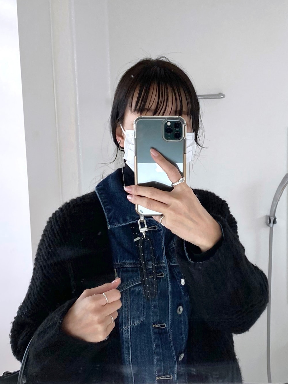 ブラック系のショルダーバッグ、ブラック系のブーツ、ブルー系のデニムパンツを着用したレディースの春コーディネートの3枚目の写真