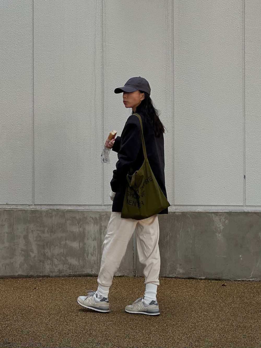 ホワイト系のその他パンツ、グレー系のスニーカー、グリーン系のトートバッグを着用したレディースの秋コーディネートの3枚目の写真