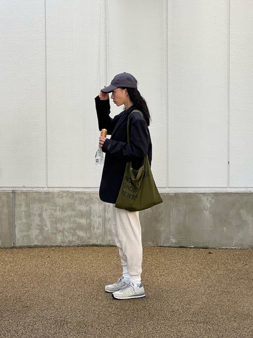 ホワイト系のその他パンツ、グレー系のスニーカー、グリーン系のトートバッグを着用したレディースの秋コーディネートの4枚目の写真