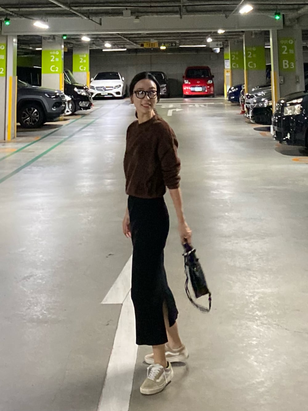 ブラック系のショルダーバッグ、ベージュ系のスニーカー、ブラウン系のニット/セーターを着用したレディースの秋コーディネートの2枚目の写真