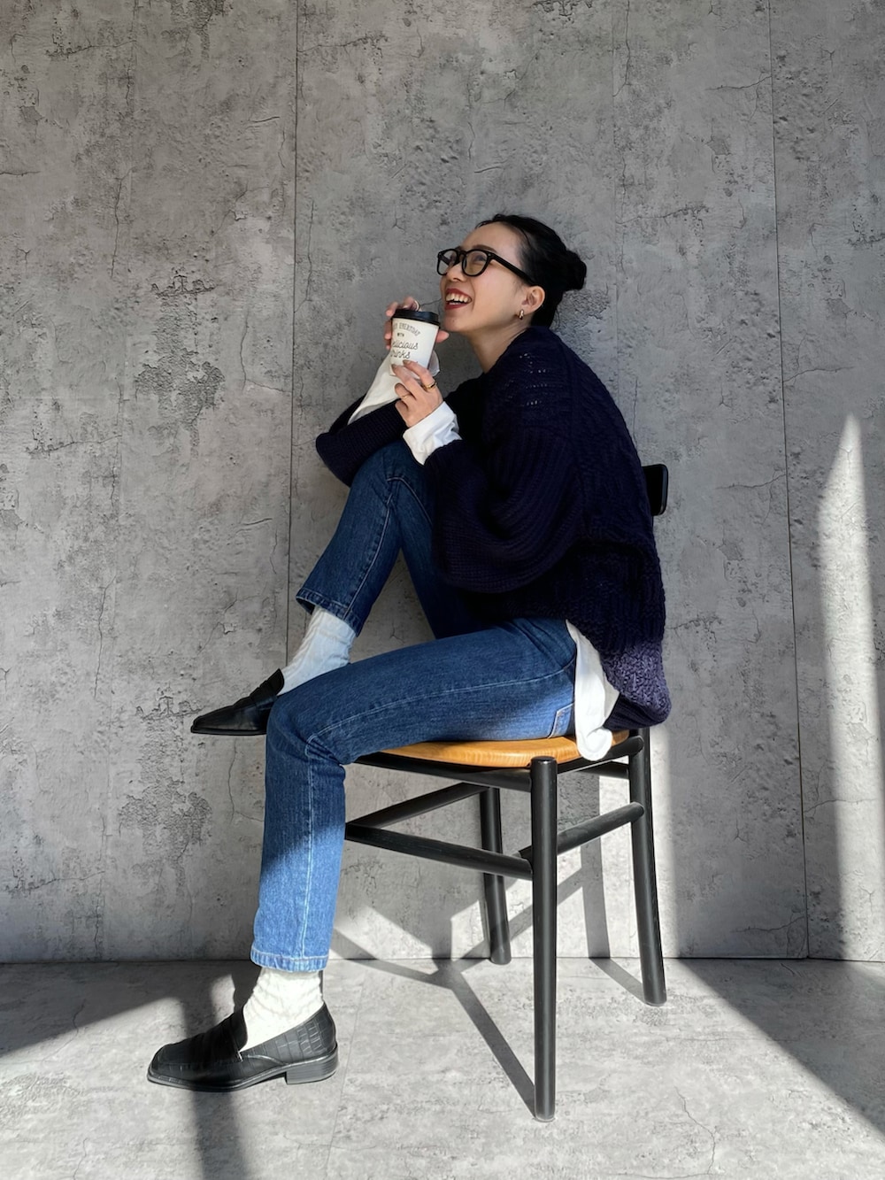 ブルー系のニット/セーター、ブルー系のデニムパンツを着用したレディースの春コーディネートの2枚目の写真