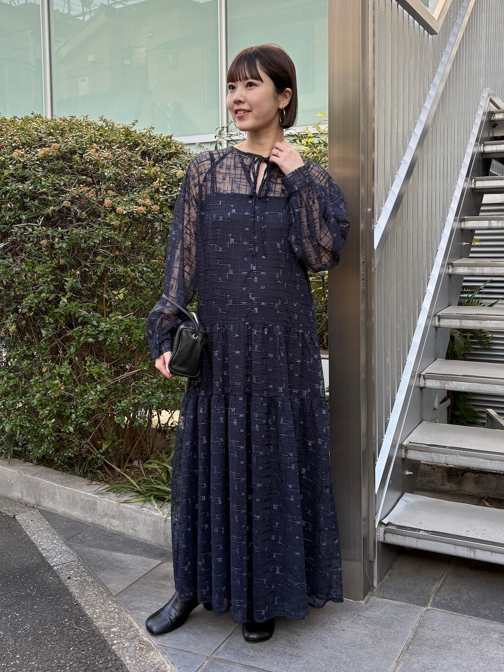 ブラック系のムートンコート、ブルー系のワンピース、ブラック系のブーツを着用したレディースの冬コーディネートの4枚目の写真