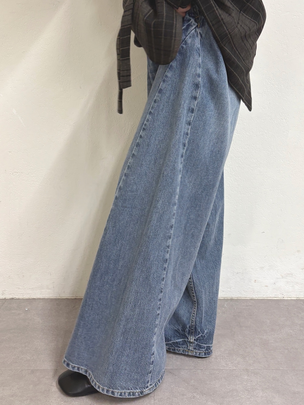 グレー系のテーラードジャケット、グレー系のTシャツ/カットソー、ブルー系のデニムパンツを着用したレディースの秋コーディネートの6枚目の写真